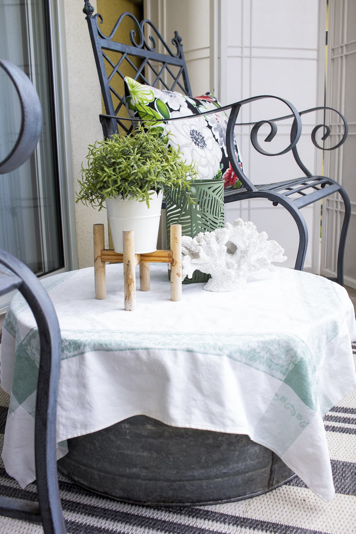 galvanized tub as table with linen table cloth and summer decor on balcony