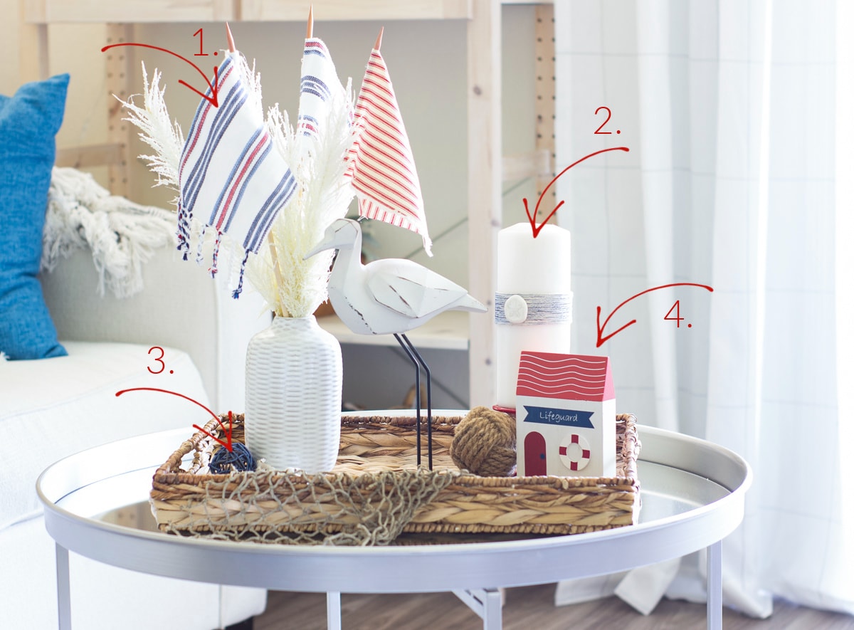 adding red white blue to a summer vignette with vase and beach grass bird figurine and candle on white holder with seagrass tray