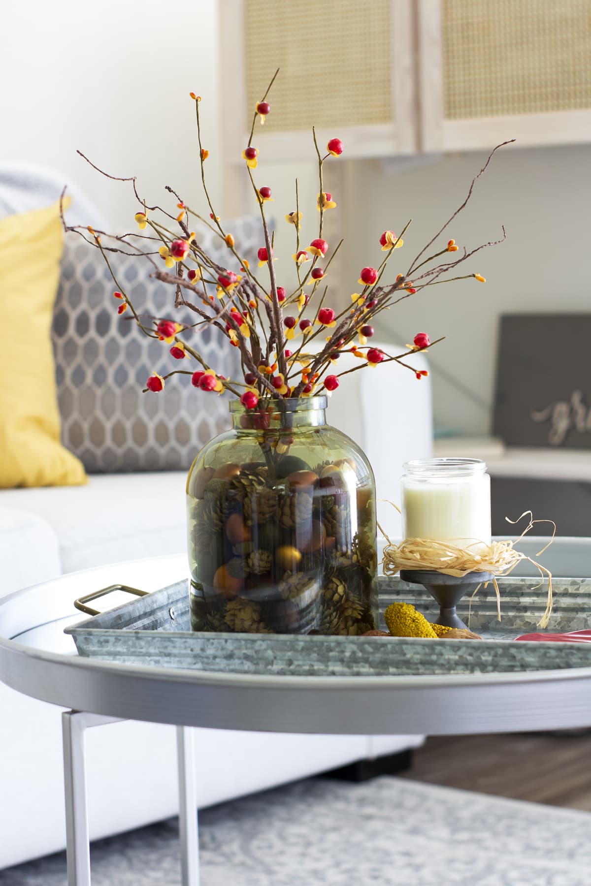 early fall vignette for a small coffee table in living room with sofa and pillows in background