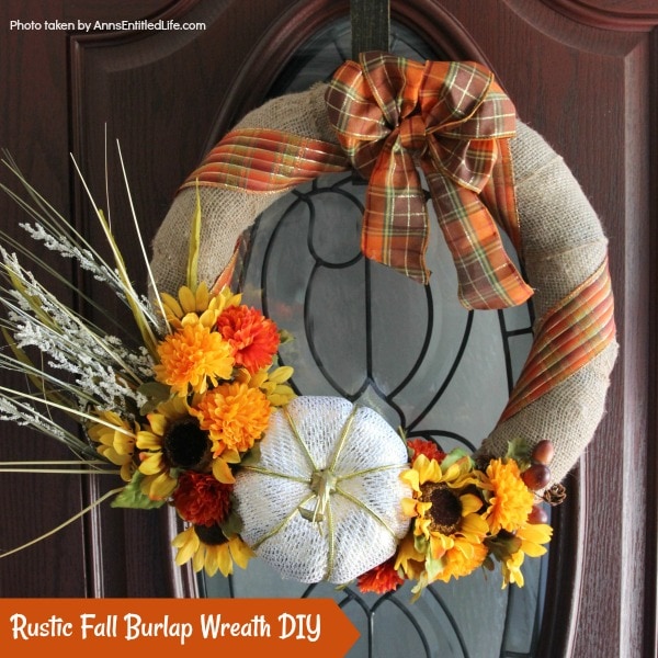 burlap wreath with pumpkin and sunflower accents on wooden door