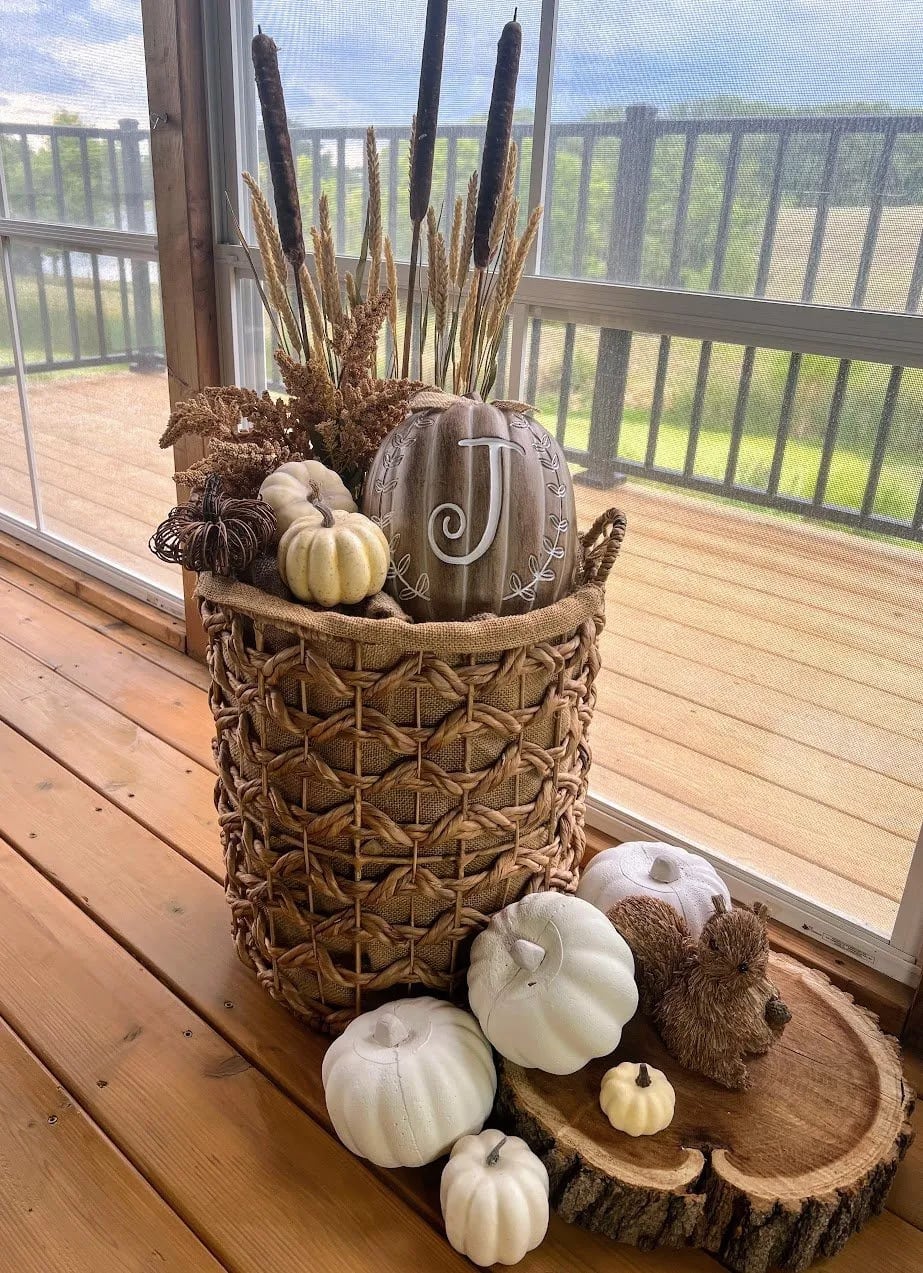 woven basket with pumpkins and fall elements inside sliding door with back balcony in background