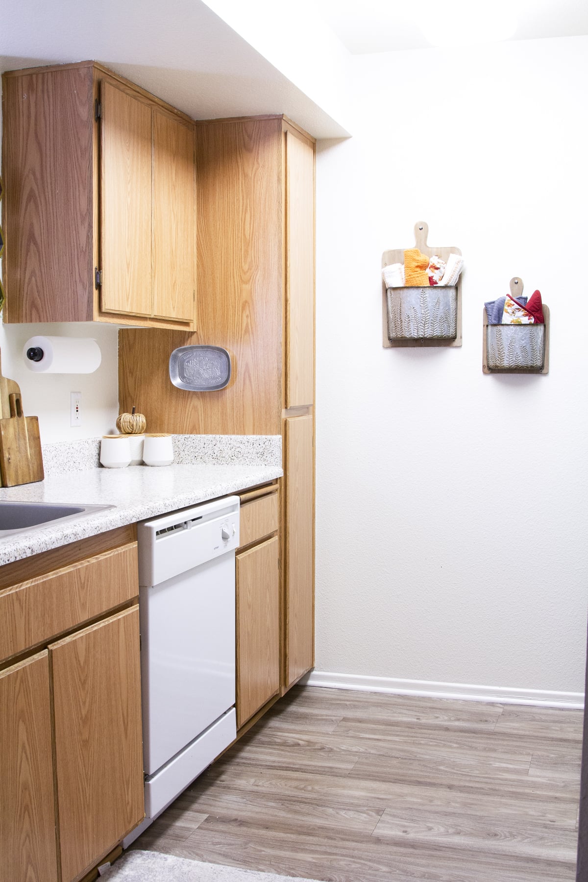 tiny apartment kitchen with wood-look cabinets and fall decor