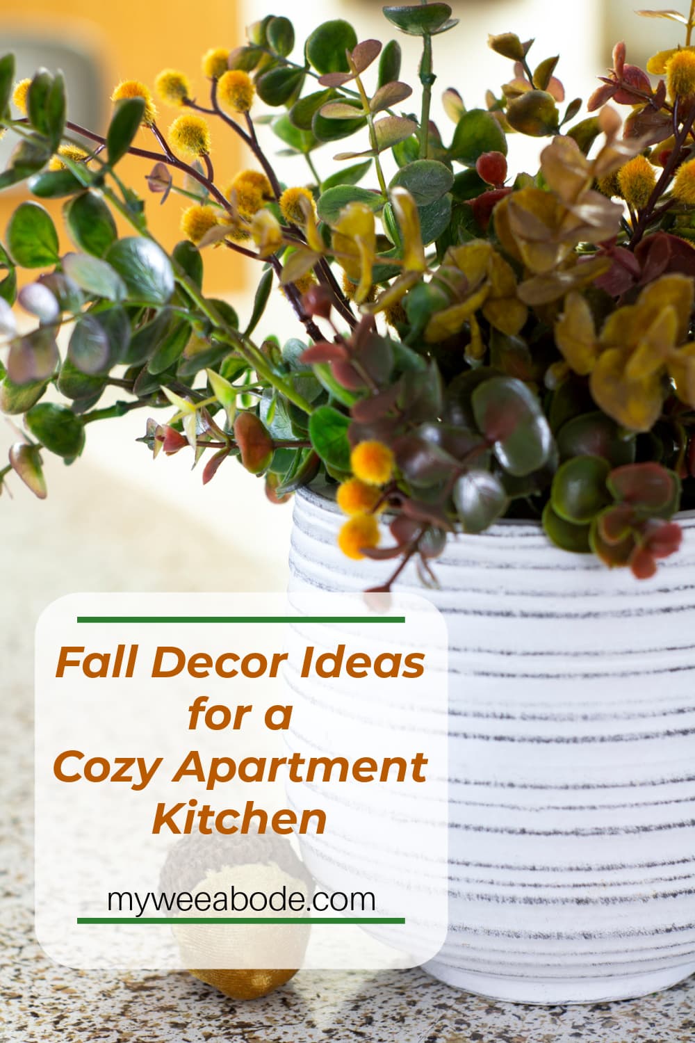 all floral arrangement in white pot and velvet acorns on kitchen counter