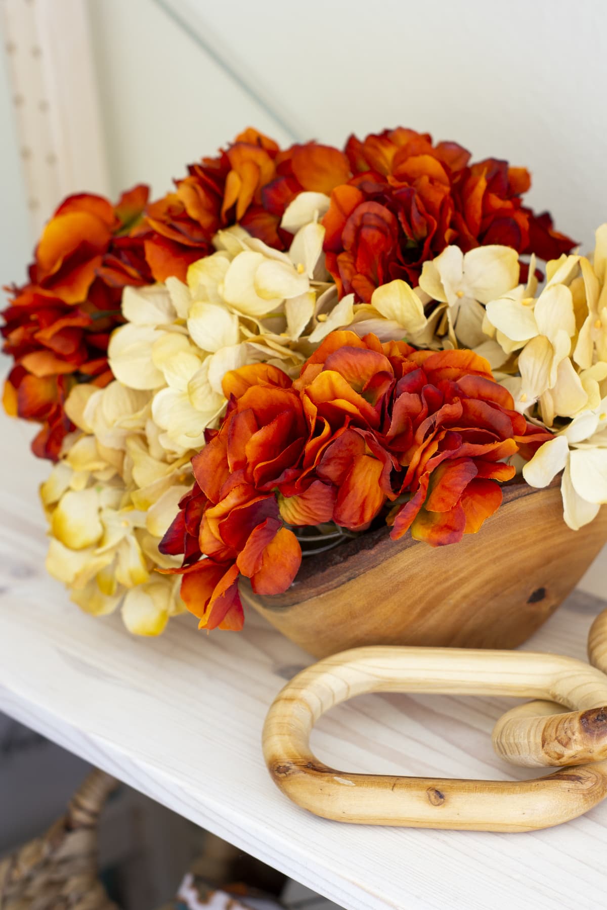 how to decorate your cozy apartment with fall faux florals in a wooden bowl and wood chain