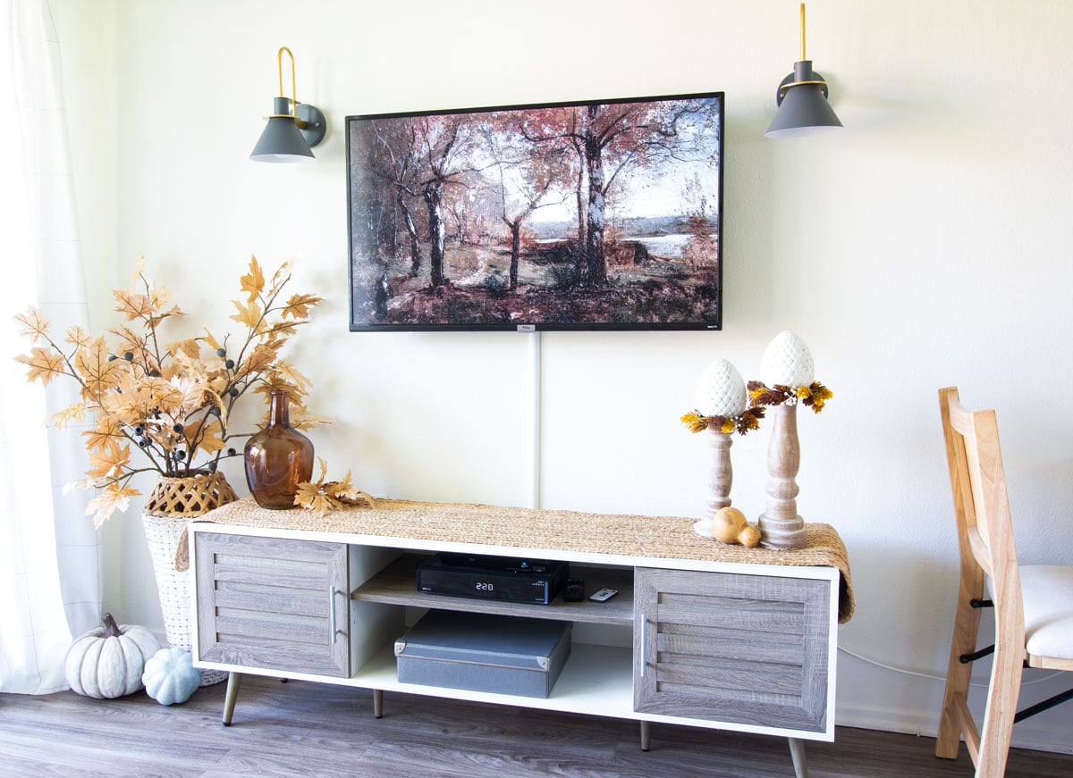tv and console decorated for fall with sconces