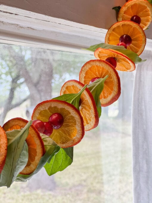 tuesday turn about 225 autumn finds orange and cranberry garland in front of window