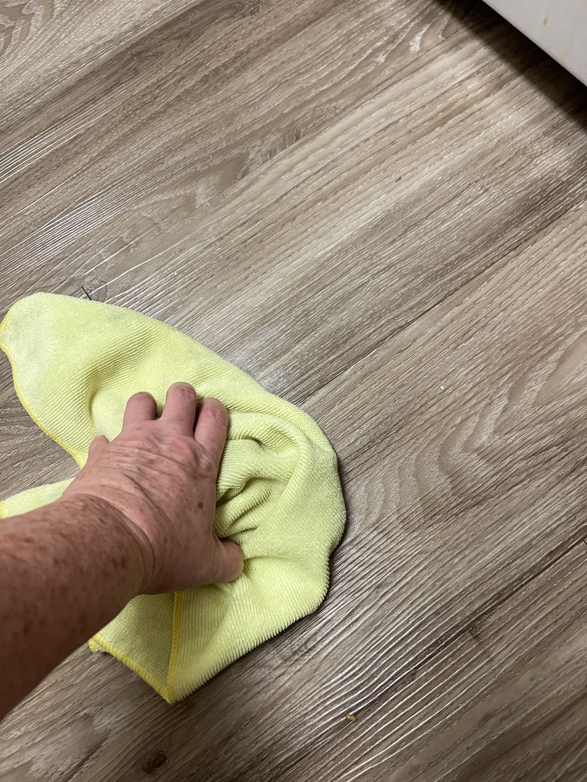 hand on yellow cloth drying LVP