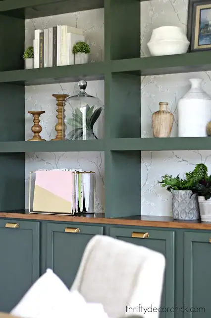 dark sage green shelving with decor accents and books