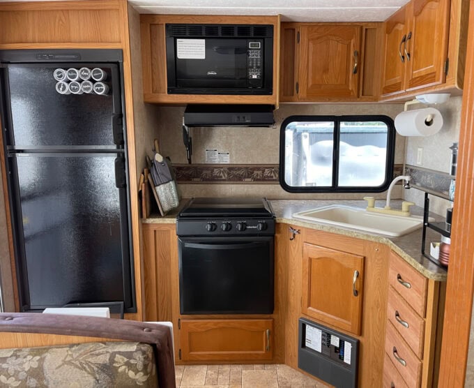 RV budget kitchen remodel with green cabinets rv kitchen before makeover with oak cabinets and black appliances