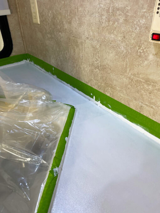 painted white counter with beige wall and green tape on edges